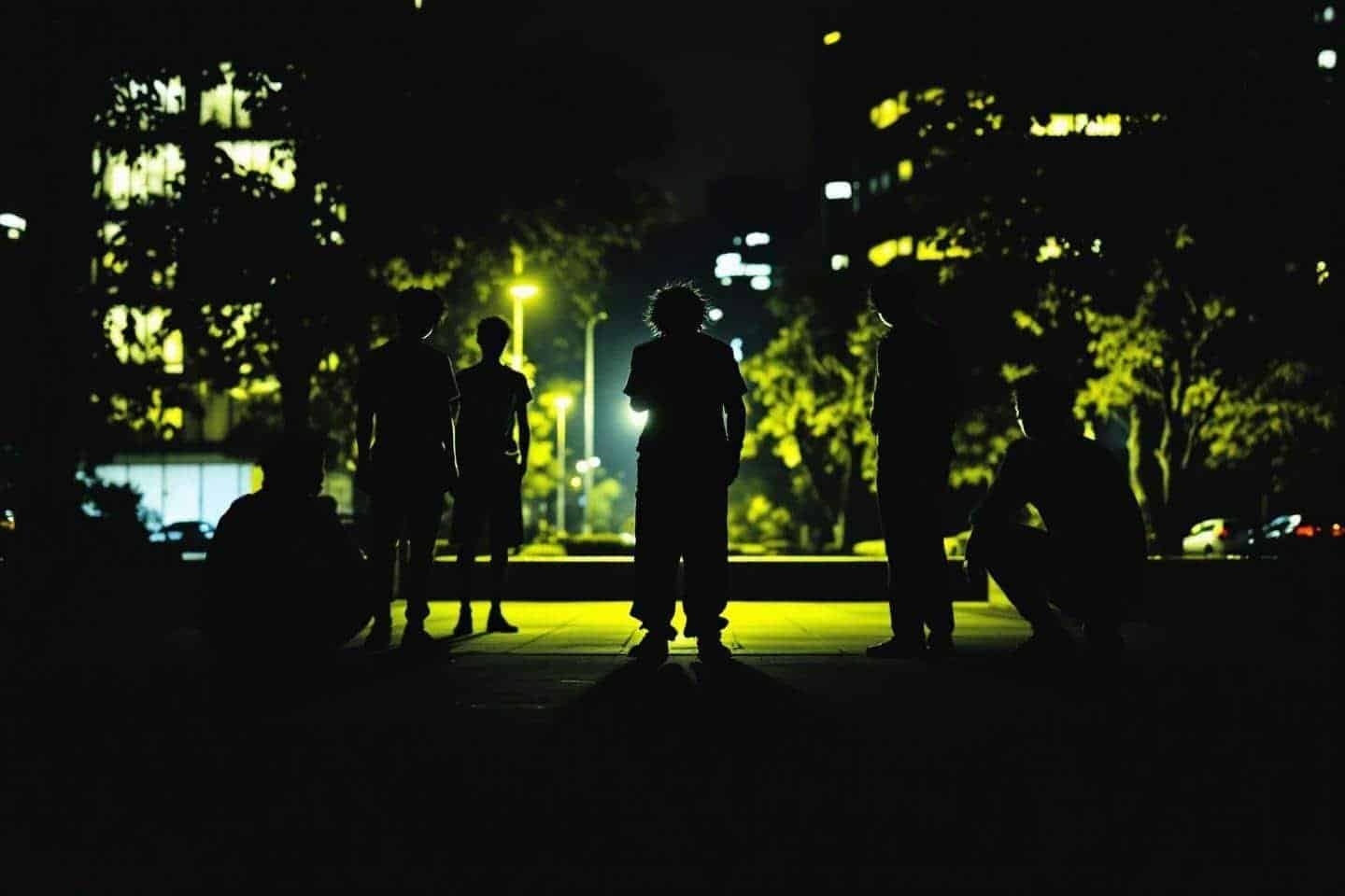 Groupe de personnes silhouettées sous un lampadaire urbain